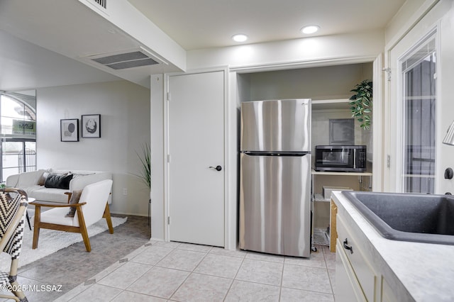 328 S Paseo Pena Unit C, Green Valley, AZ 85614 - kitchen featuring light countertops, light tile patterned floors, a sink, visible vents, and appliances with stainless steel finishes