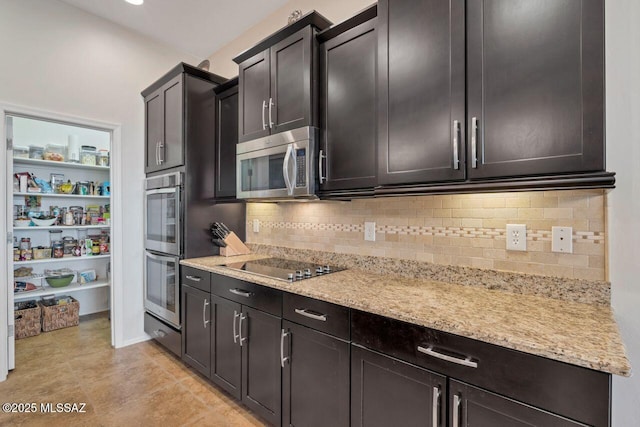 kitchen featuring stainless steel appliances, light tile patterned flooring, light stone counters, and tasteful backsplash