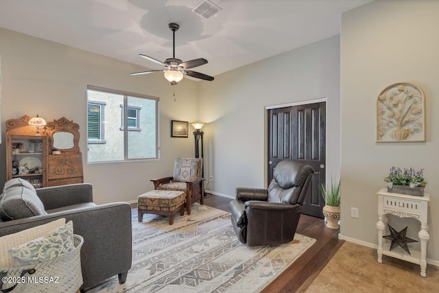 living room featuring visible vents, baseboards, and ceiling fan
