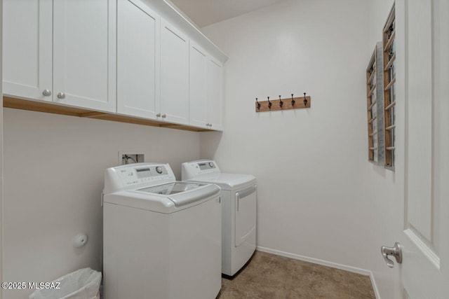 clothes washing area featuring cabinets and washing machine and clothes dryer