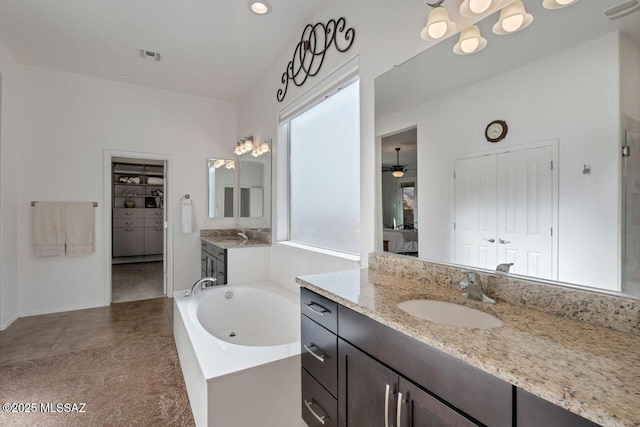 full bath featuring two vanities, a garden tub, visible vents, and a sink