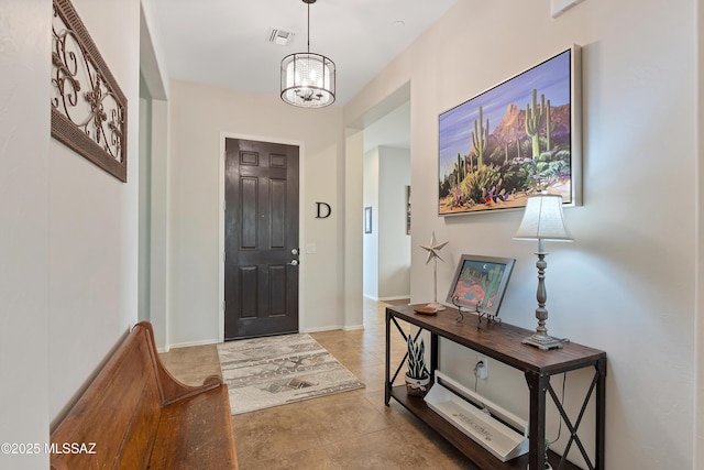 foyer entrance with light tile patterned flooring and a chandelier