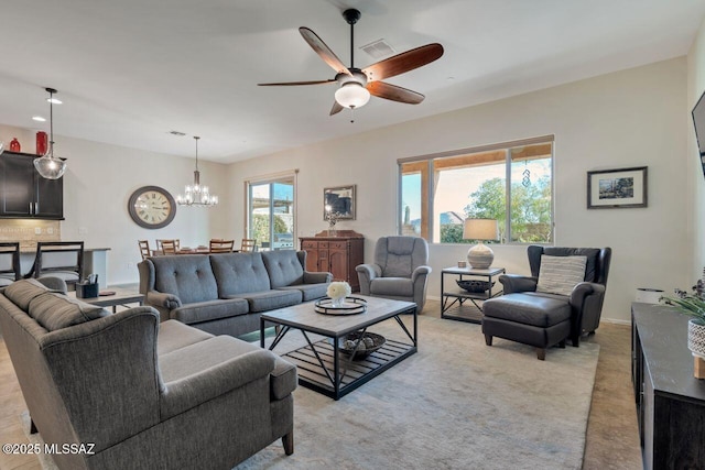living area with light colored carpet, baseboards, visible vents, and ceiling fan with notable chandelier