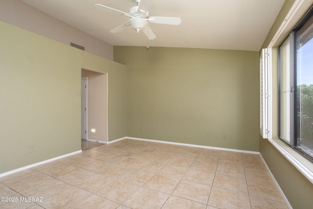 unfurnished room featuring baseboards, visible vents, ceiling fan, vaulted ceiling, and light tile patterned flooring