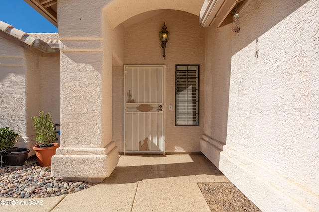 property entrance with stucco siding