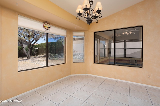 empty room with tile patterned flooring, baseboards, and a notable chandelier