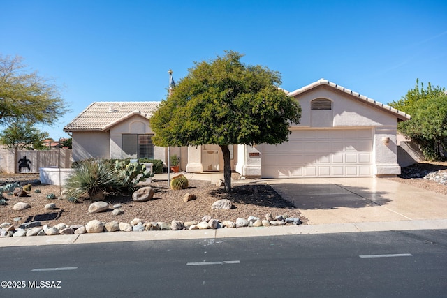 view of front of property featuring driveway, an attached garage, a tile roof, and stucco siding