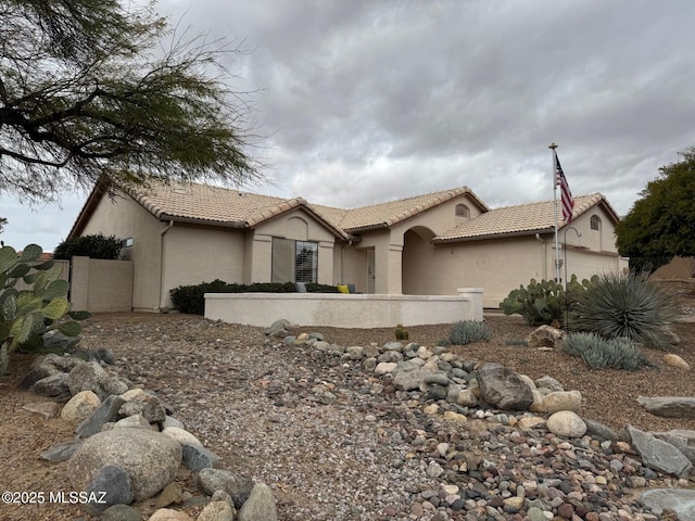 view of front of home with a garage, a tiled roof, and stucco siding