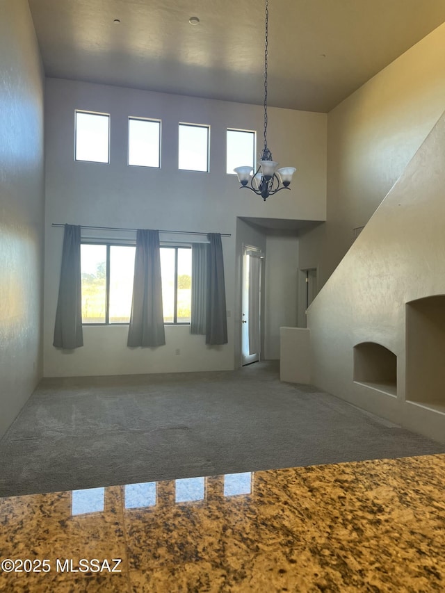 interior space with a towering ceiling and an inviting chandelier