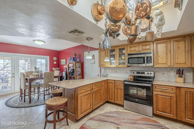 3910 S Via Del Ruisenor, Green Valley, AZ 85622 - kitchen with pendant lighting, a kitchen breakfast bar, stainless steel appliances, decorative backsplash, and kitchen peninsula