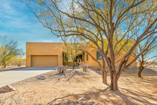 pueblo revival-style home featuring a garage