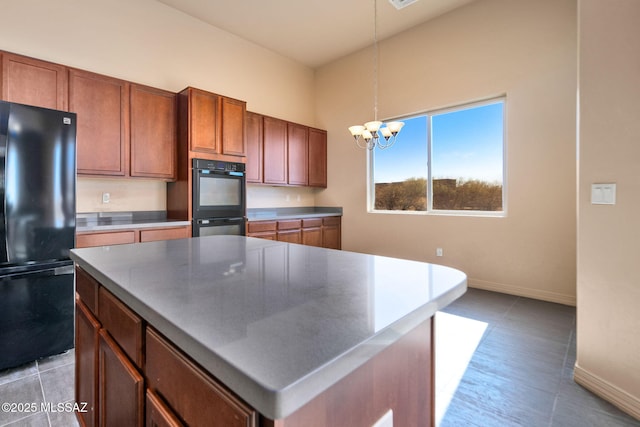 kitchen featuring a notable chandelier, hanging light fixtures, black appliances, and a center island