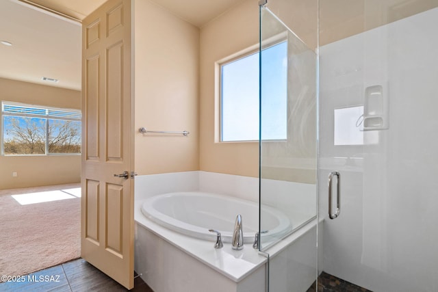 bathroom with tile patterned flooring and separate shower and tub