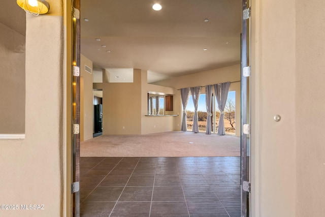 corridor featuring dark colored carpet