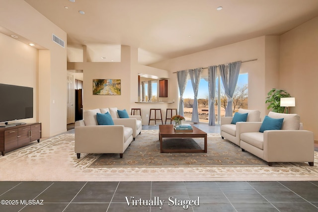 tiled living room with a high ceiling