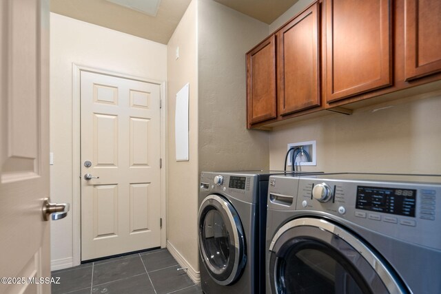 washroom featuring cabinets, washer and dryer, and dark tile patterned floors