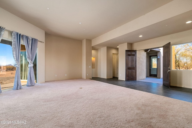 unfurnished room with dark colored carpet