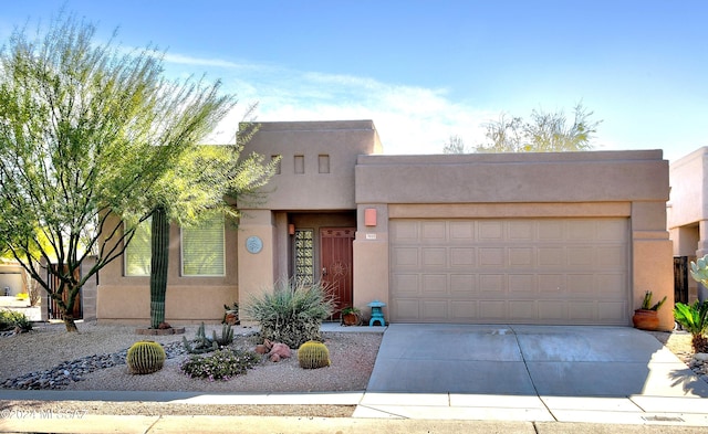 pueblo revival-style home with a garage