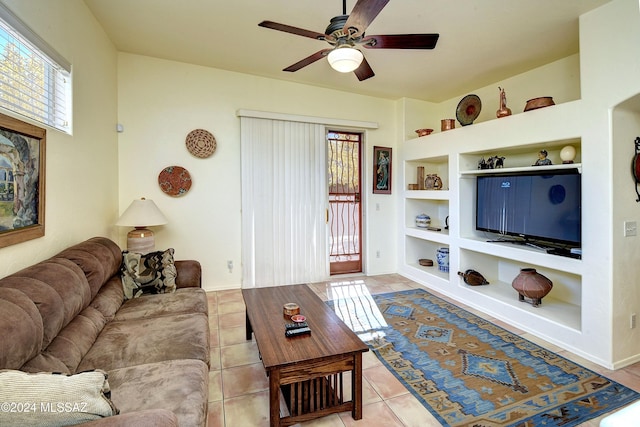 tiled living room featuring built in shelves and ceiling fan