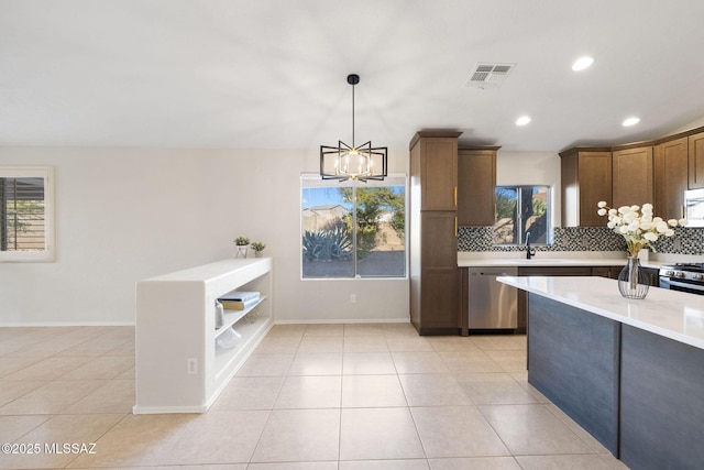 kitchen featuring stainless steel appliances, decorative light fixtures, decorative backsplash, and a wealth of natural light