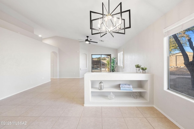 unfurnished dining area featuring light tile patterned floors, ceiling fan with notable chandelier, and vaulted ceiling