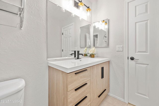 bathroom with vanity, tile patterned floors, and toilet