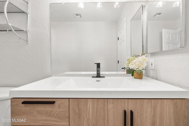 bathroom featuring vanity and toilet