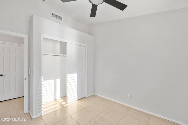 unfurnished bedroom with light tile patterned floors, a closet, and ceiling fan