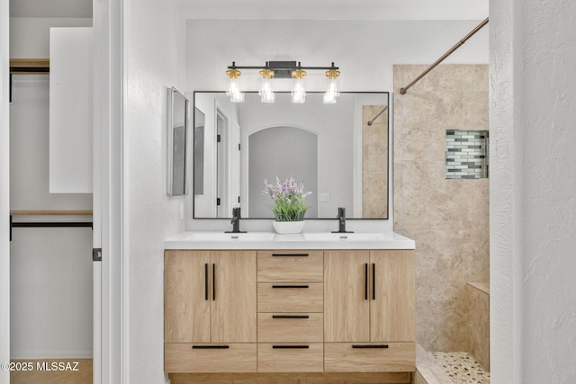 bathroom featuring vanity and tiled shower