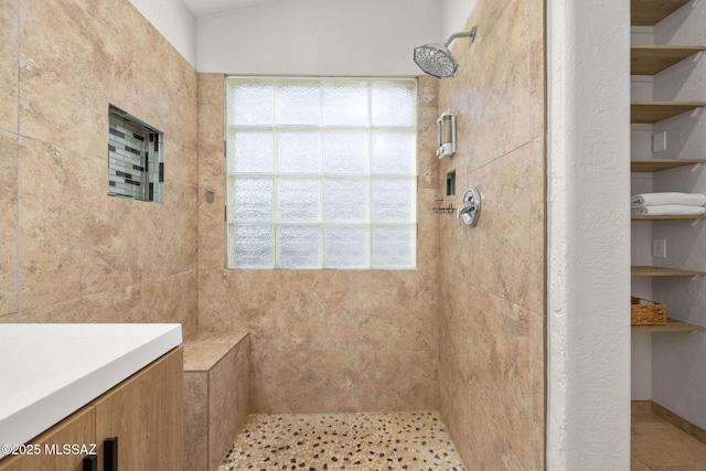 bathroom with a healthy amount of sunlight and a tile shower