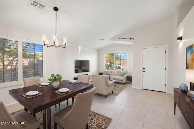 dining area featuring lofted ceiling, light tile patterned floors, and an inviting chandelier