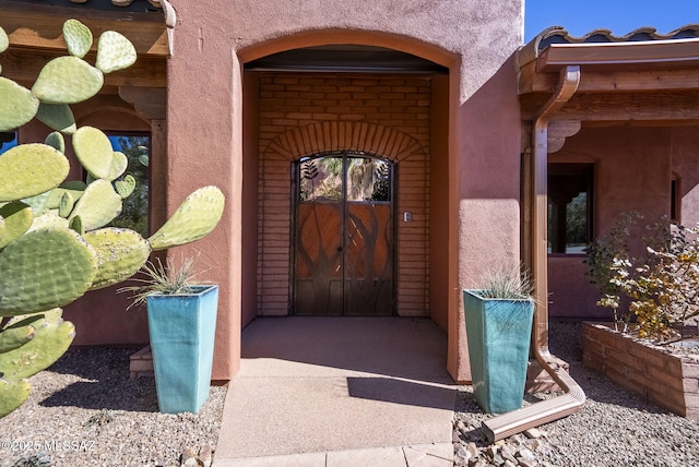 doorway to property featuring stucco siding