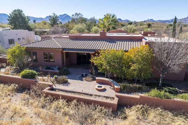 rear view of house featuring a mountain view and a patio area