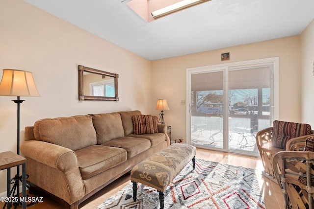 living room with hardwood / wood-style floors and a skylight