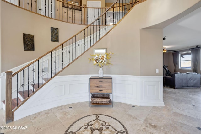 stairway featuring a towering ceiling