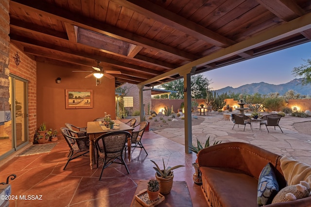 patio terrace at dusk with a mountain view and ceiling fan