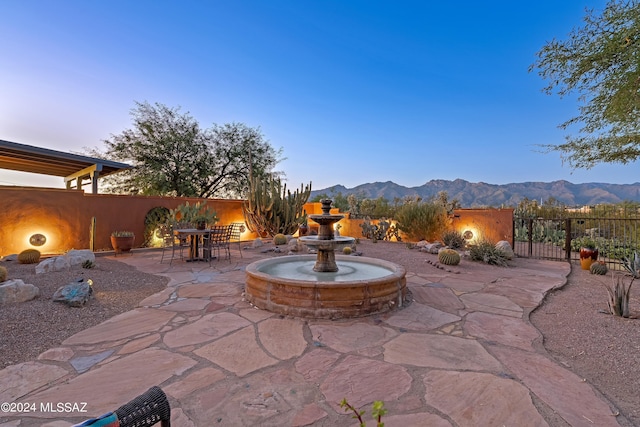 patio terrace at dusk featuring a mountain view