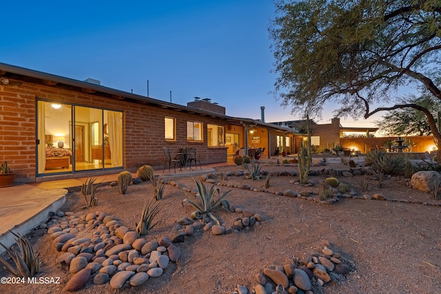 back house at dusk with a patio