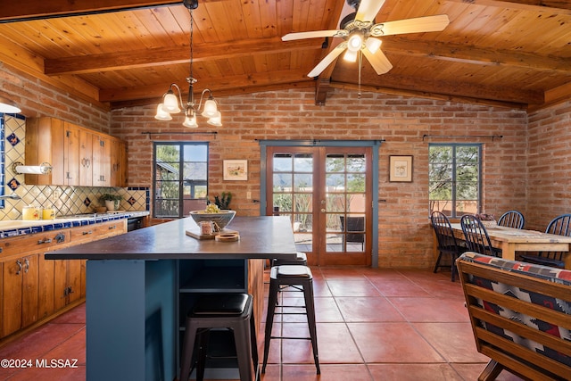 kitchen with beam ceiling, plenty of natural light, french doors, and brick wall