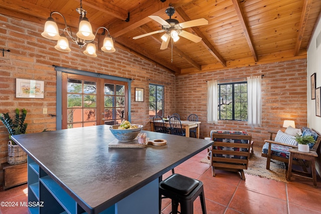 tiled dining space with brick wall, vaulted ceiling with beams, wood ceiling, and french doors