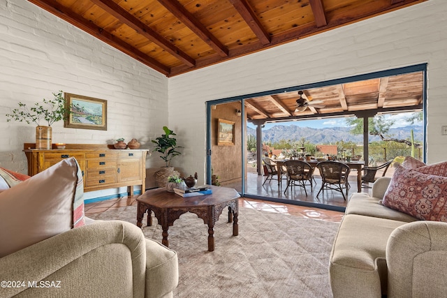 tiled living room with wood ceiling, ceiling fan, a mountain view, and vaulted ceiling with beams