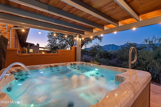 exterior space with a hot tub and a mountain view