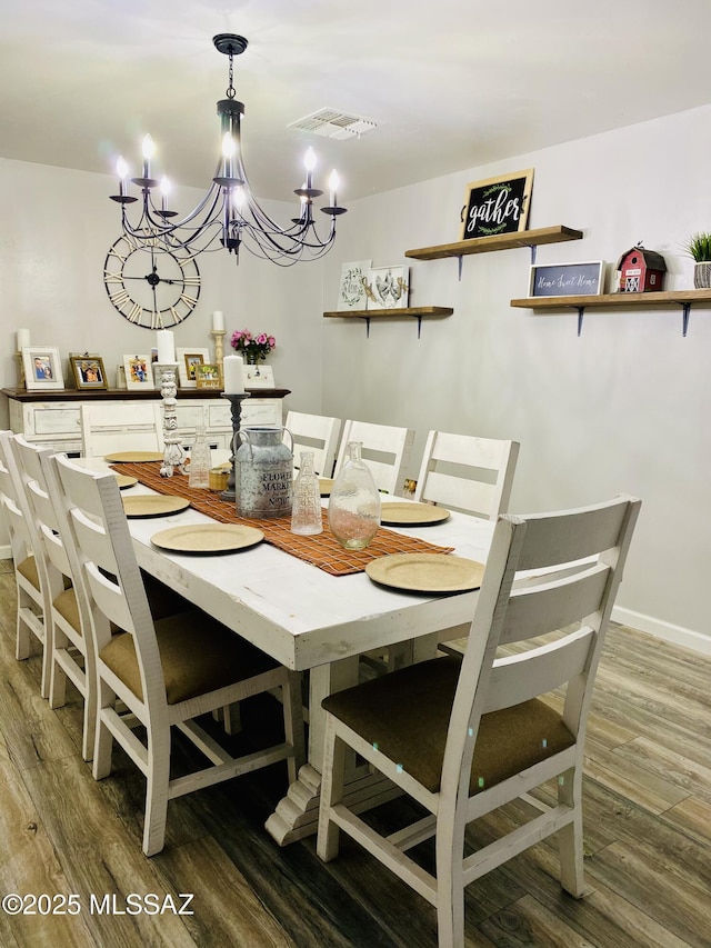 dining room featuring hardwood / wood-style flooring and an inviting chandelier