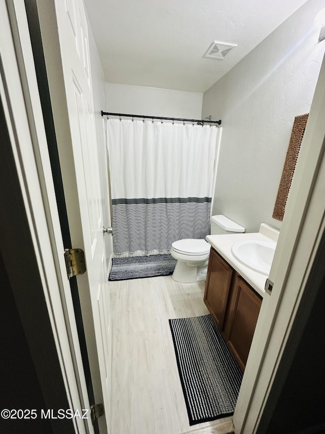 bathroom featuring hardwood / wood-style flooring, vanity, and toilet