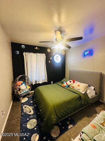 bedroom with ceiling fan and dark colored carpet