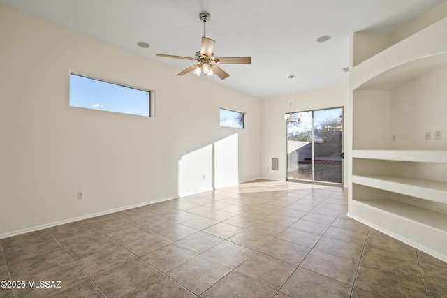 tiled spare room with ceiling fan with notable chandelier