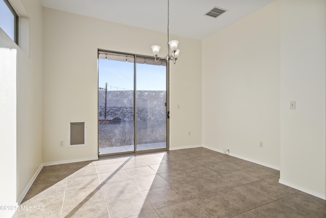 tiled empty room with a notable chandelier