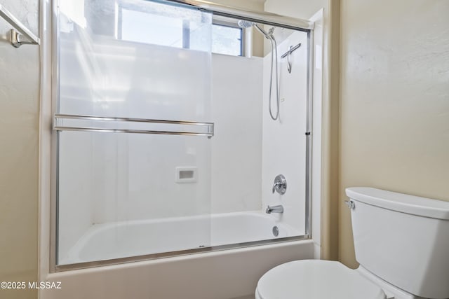 bathroom with enclosed tub / shower combo and toilet