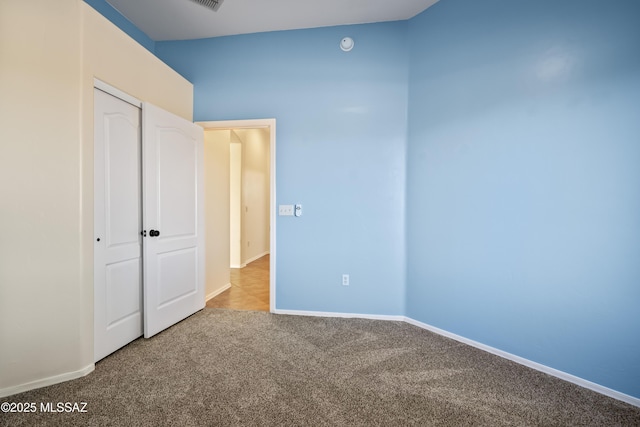 unfurnished bedroom with light carpet and a closet