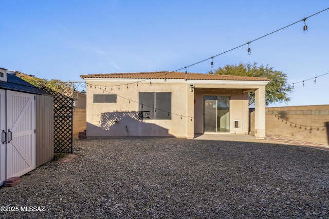 back of house with a patio area and a storage shed